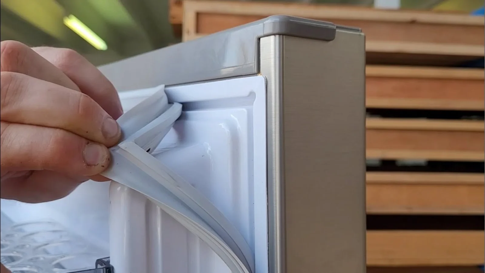 How to repair a freezer door seal showing a loose gasket causing cold air leaks